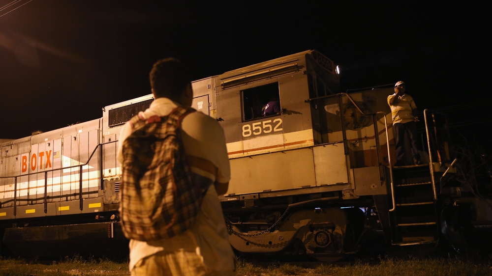 A Central American watches as a freight train arrives in Tenosique, Mexico. Many migrants have perished riding atop “La Bestia” on their journey to the US border