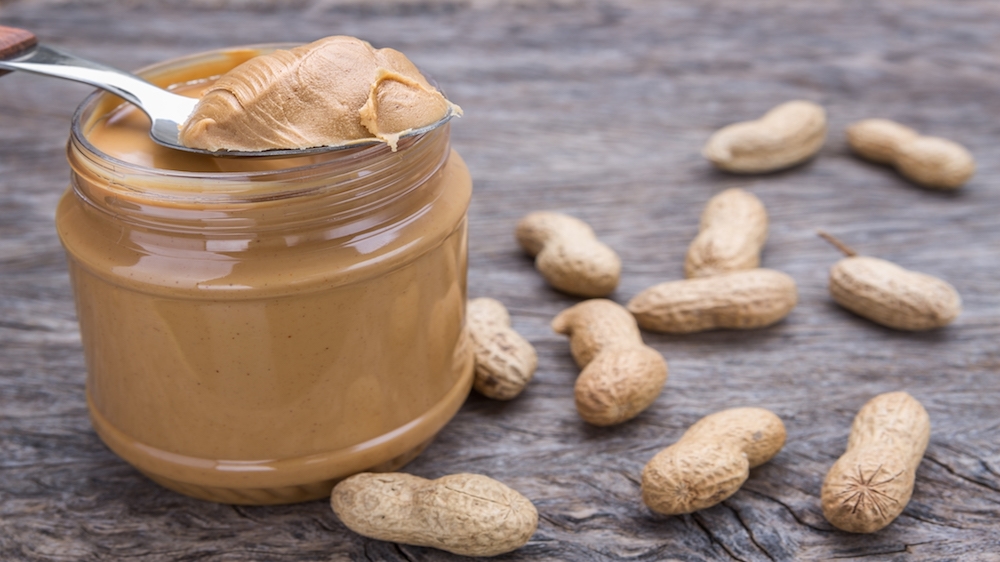 Peanut cream in spoon. Dietary foods for the heart.
