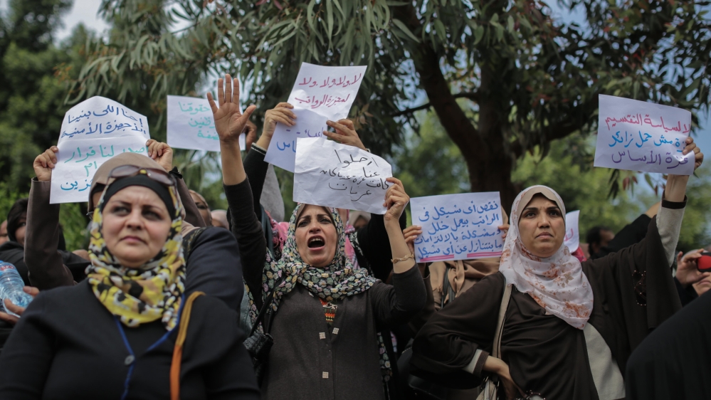 During protests against pay cuts in Gaza. One sign reads “No to the salary massacre” and another, “No to the policies of division, Gaza is not a burden, Gaza is the core.” [Ezz Zanoun]