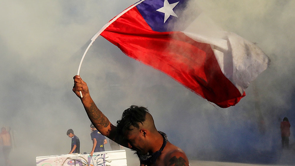 A demonstrator holds a Chile flag during a protest against Chile’s government at Plaza Italia in Santiago, Chile