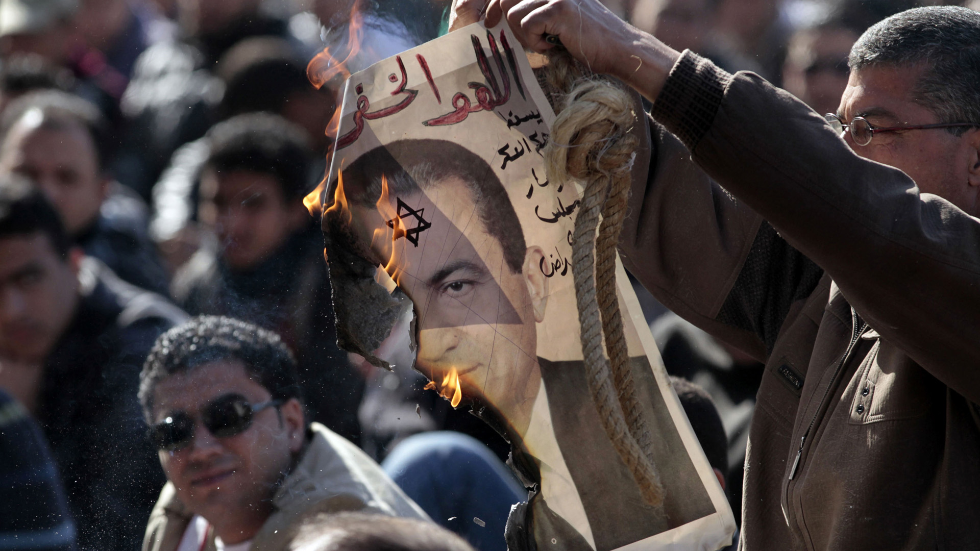 A protester burns a picture of former Egyptian President Hosni Mubarak in Cairo on December 23, 2011