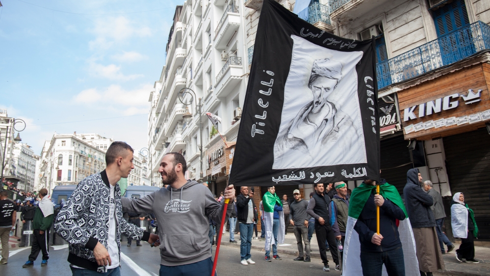 Former political prisoner Mohamed Tadjadit, left, speaks with a protester.
