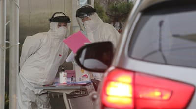Medical staff wearing protective suites work to take samples from drivers with suspected symptoms of the coronavirus at a “drive-through” virus test facility in Goyang, South Korea