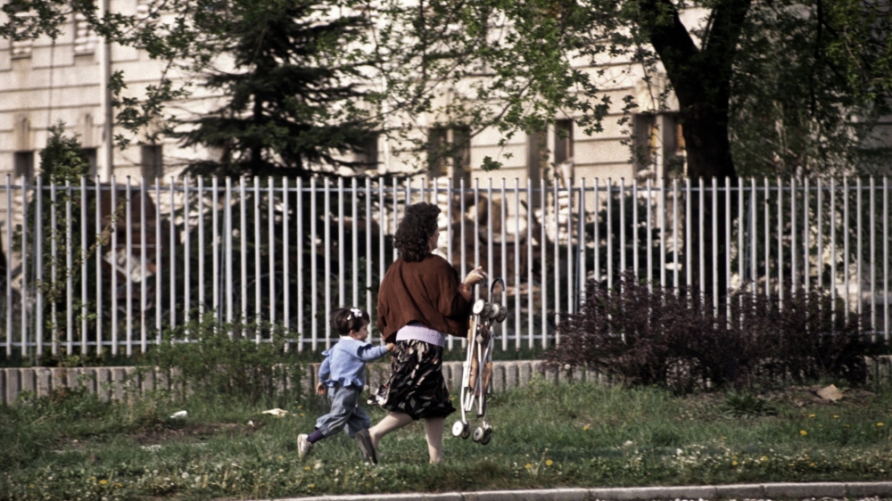 A mother and child run for their lives along Sniper Alley to avoid being hit by Serb sniper fire in Sarajevo in 1995