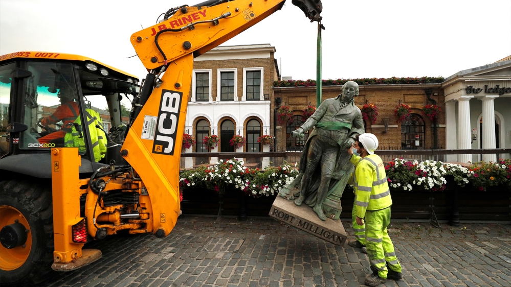 A statue of Robert Milligan, a Scottish slave-trader, is removed by workers from outside the Museum of London Docklands near Canary Wharf, London on June 9, 2020