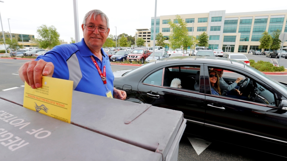 People drop off their mail-in ballots in the US presidential primary election in San Diego, California
